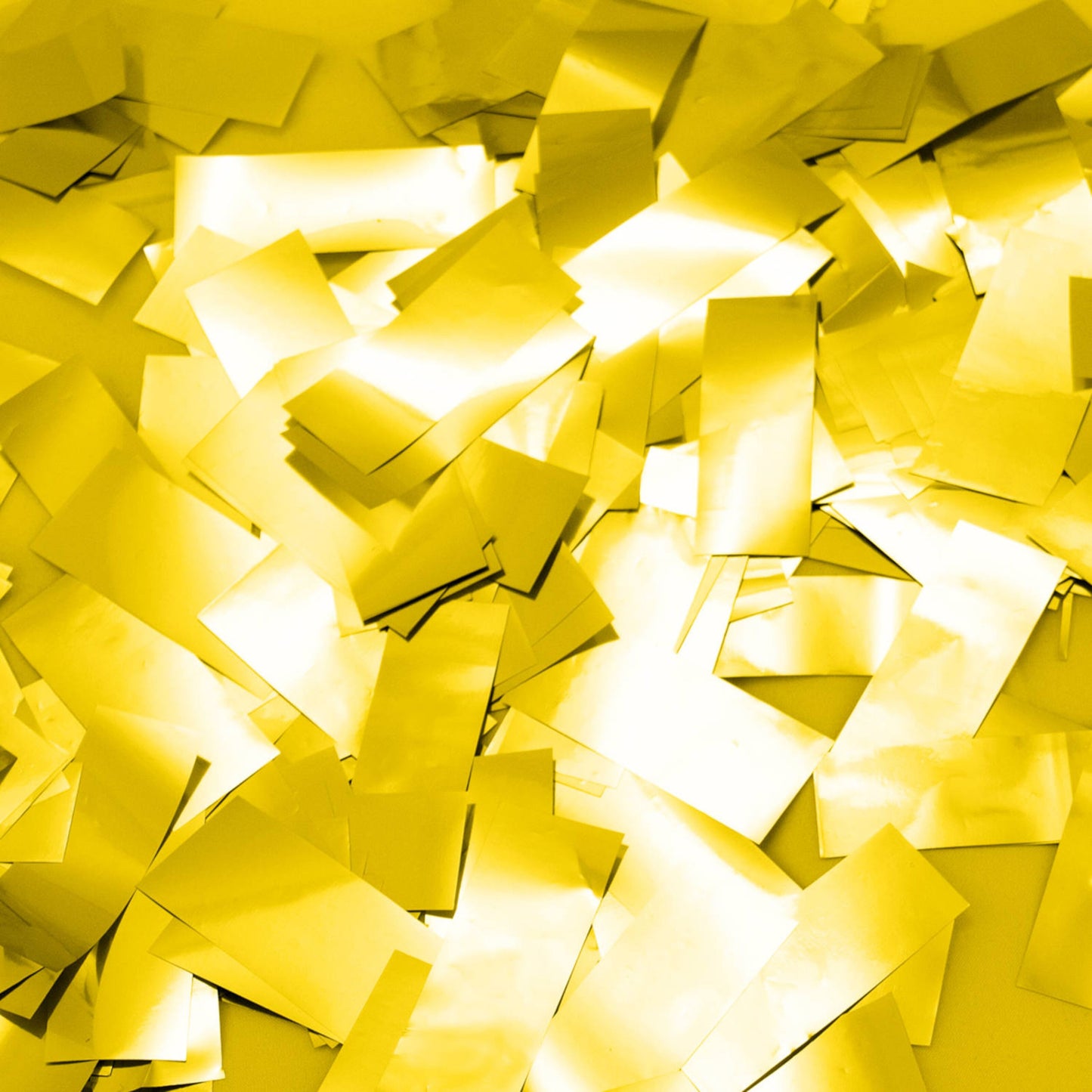 Guld metallic rektangulære ark og XL papirstrimler fra Konfettikanon med papirstrimler XL spredt og lysreflekterende.