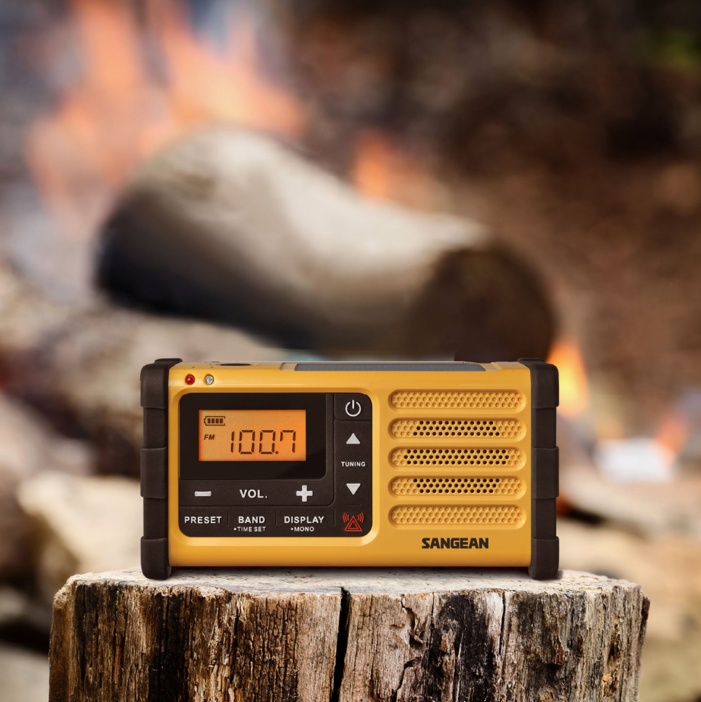 Sangean håndsvingradio FM USB-C i gul, viser 100.7, flere knapper og drejeskiver synlige på fronten.