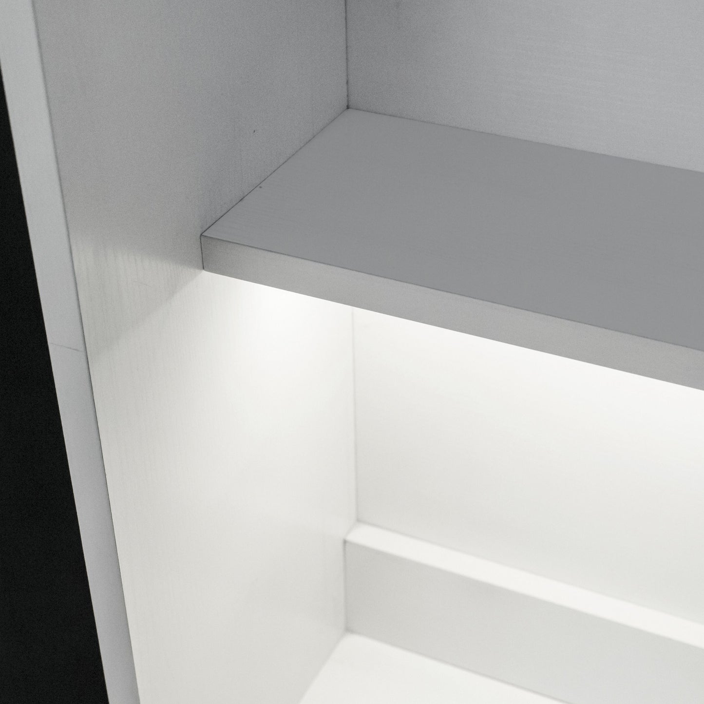 Aluminiumsprofil hjørnemontering til LED-strips monteret under hylde i hvidt skab, jævn belysning i rummet.