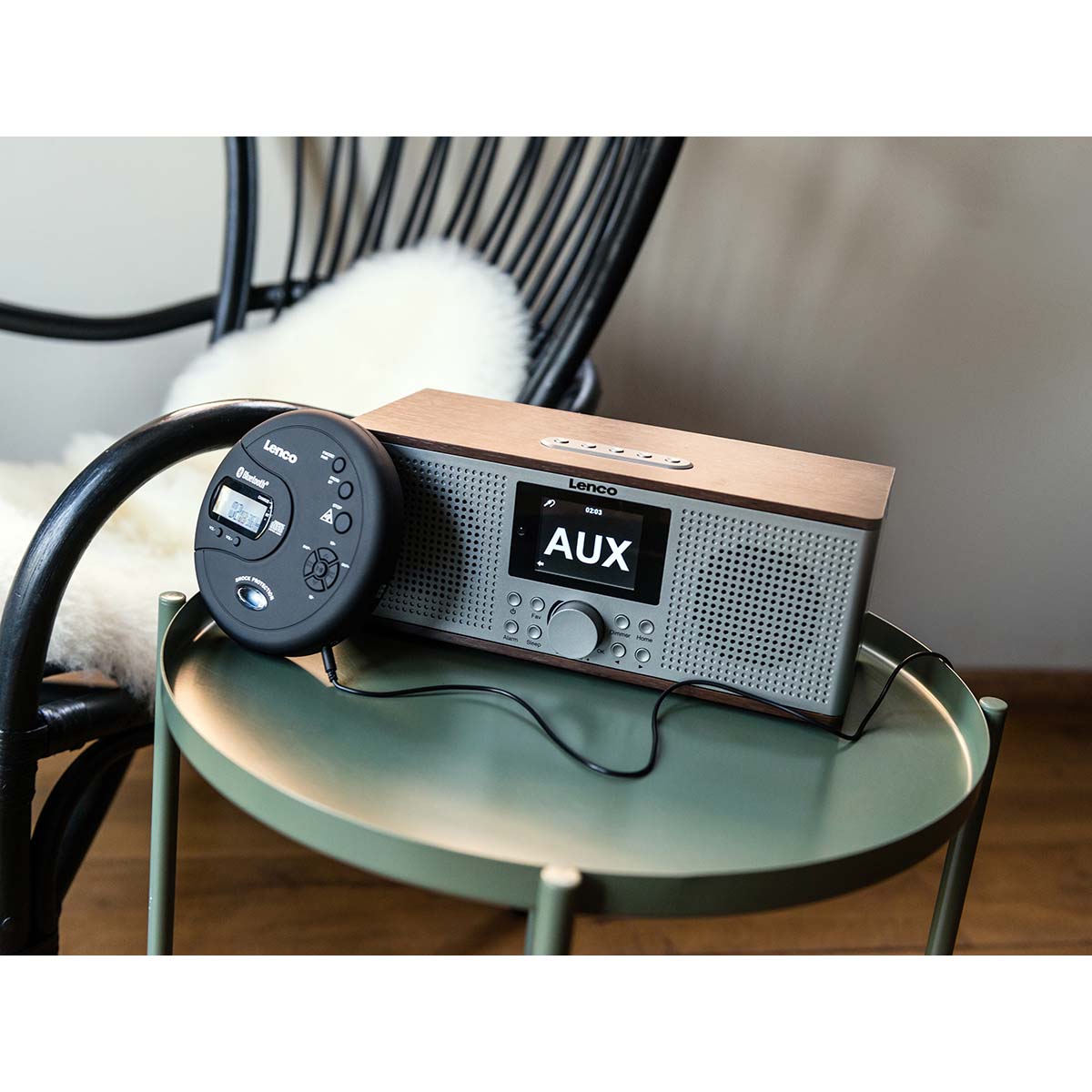 Lenco bærbar Bluetooth CD-MP3-afspiller sort med antishock, tilsluttet bordradio via kabel, radio viser "AUX.