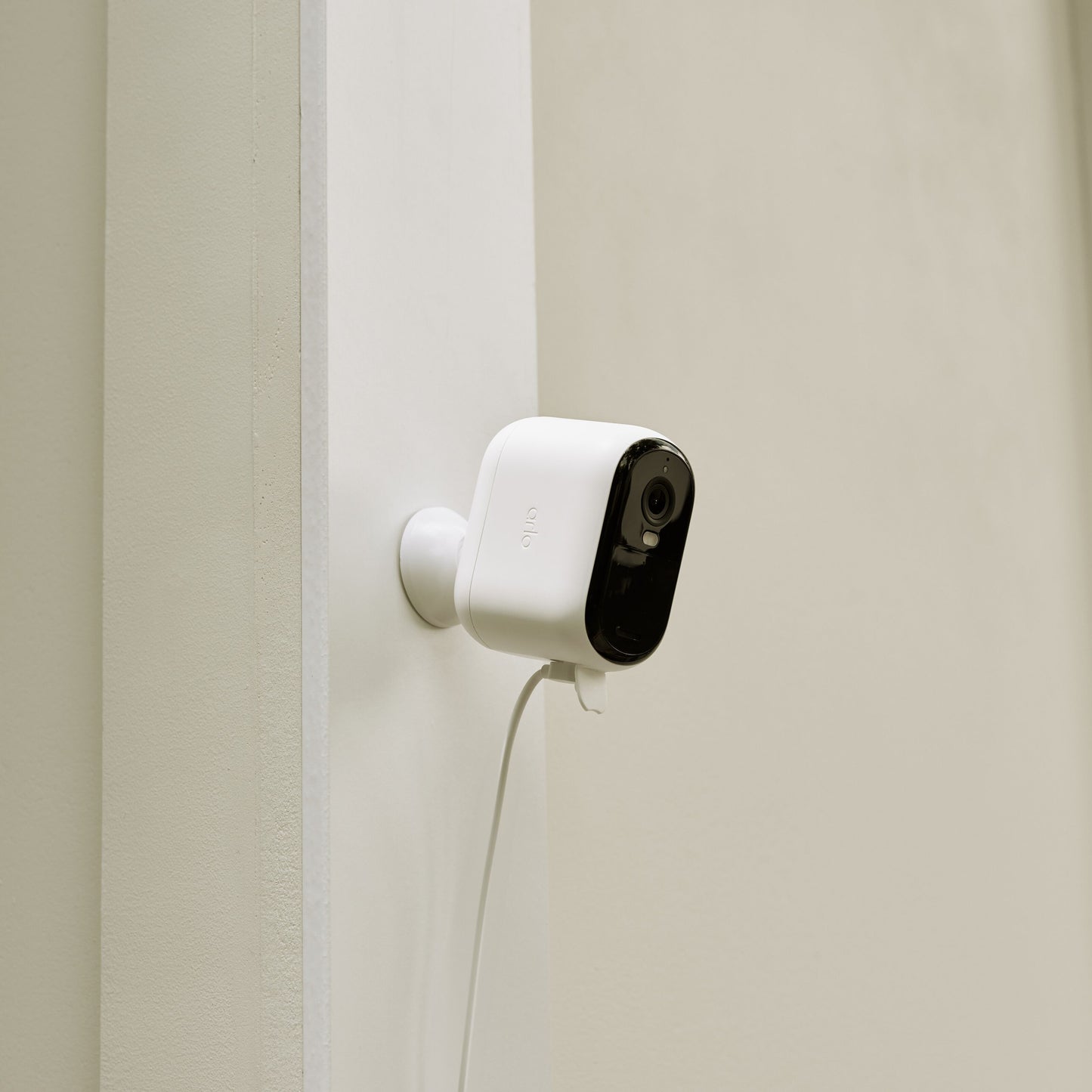 Arlo sikkerhedskamera hvid/sort front, monteret på væg med Arlo Essential 2 udendørskabel synligt nedenunder.