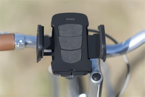 DELTACO cykelholder til smartphone, universal, monteret på cykelstyret med et brunt håndtag, der ses til venstre.