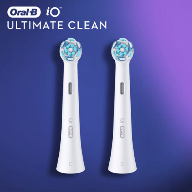 Oral-B iO Ultimate Clean børstehoveder, 2-pak, hvid, med logo og produktnavn synligt på en blå-lilla baggrund.