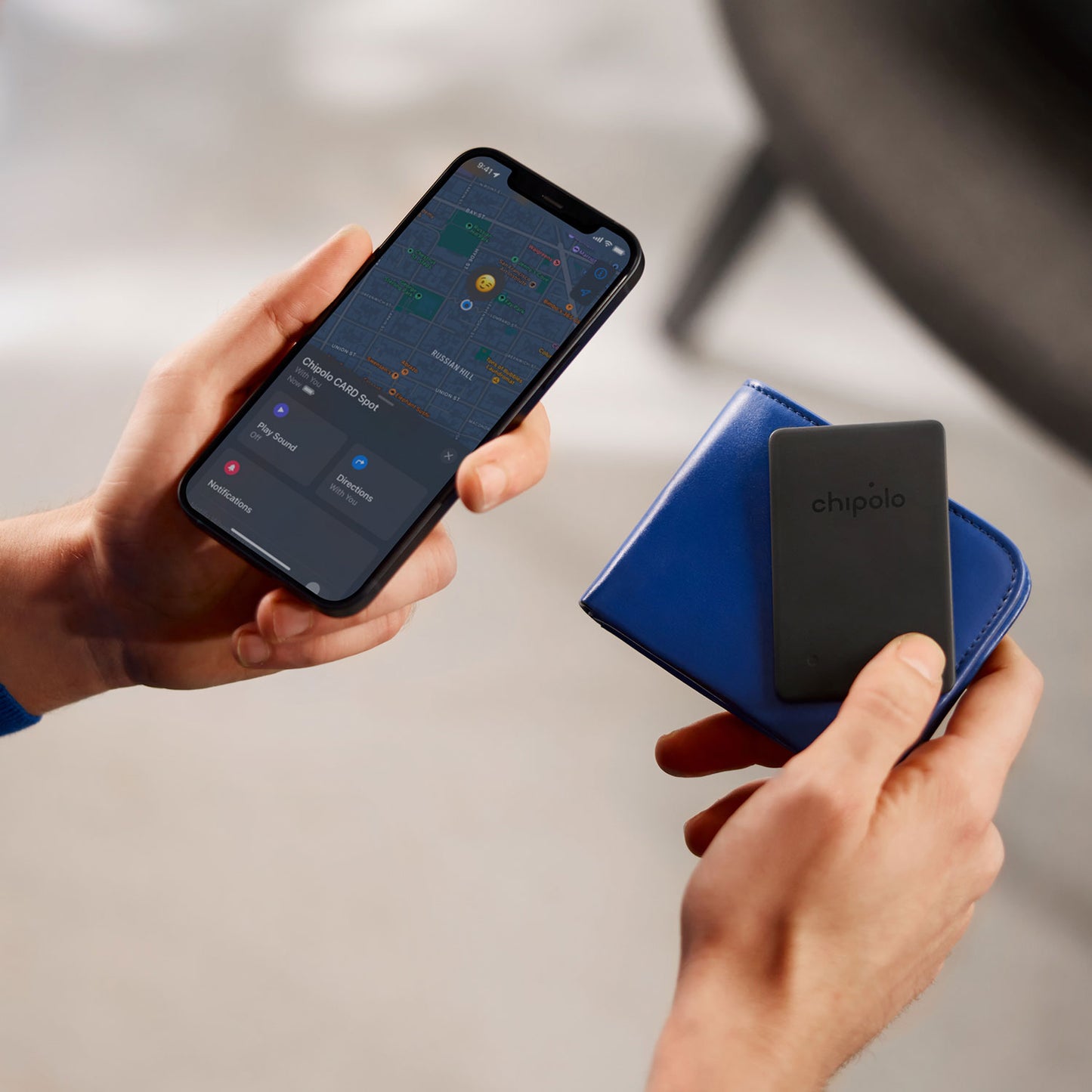 Chipolo One Spot sort Bluetooth nøglefinder vist i blå pung, Apple Find My app vises på smartphone.