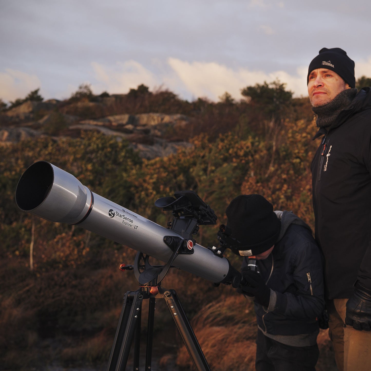 Celestron Powerseeker 60 AZ teleskop på stativ udendørs, en person bruger teleskopet, en anden står ved siden af.