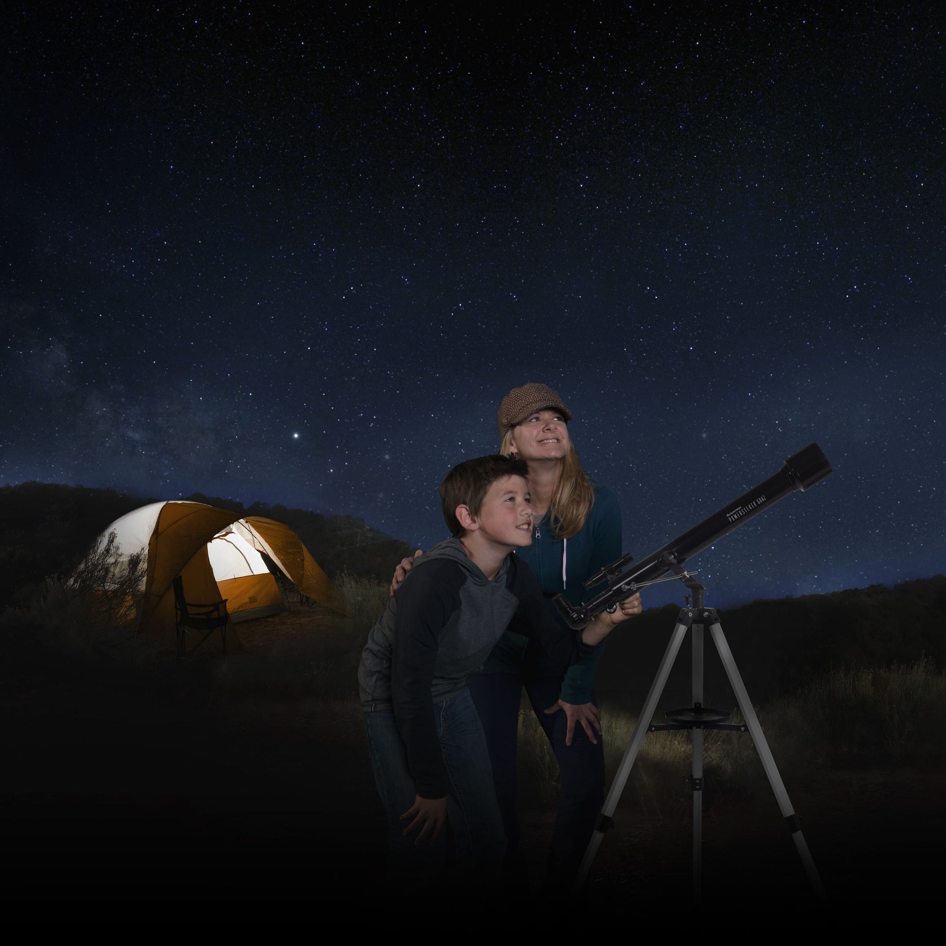 Celestron Powerseeker 60 AZ teleskop med azimutal montering i brug om natten, telt svagt oplyst i baggrunden.