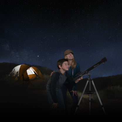 Celestron Powerseeker 60 AZ teleskop med azimutal montering i brug om natten, telt svagt oplyst i baggrunden.