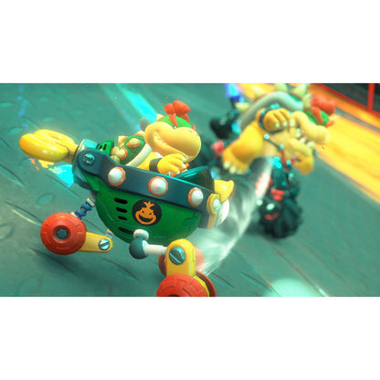 Bowser Jr. i grøn kart med rødt hjul kører på bane i Mario Kart Verden Switch 2, forfulgt af Bowser og andre racere.