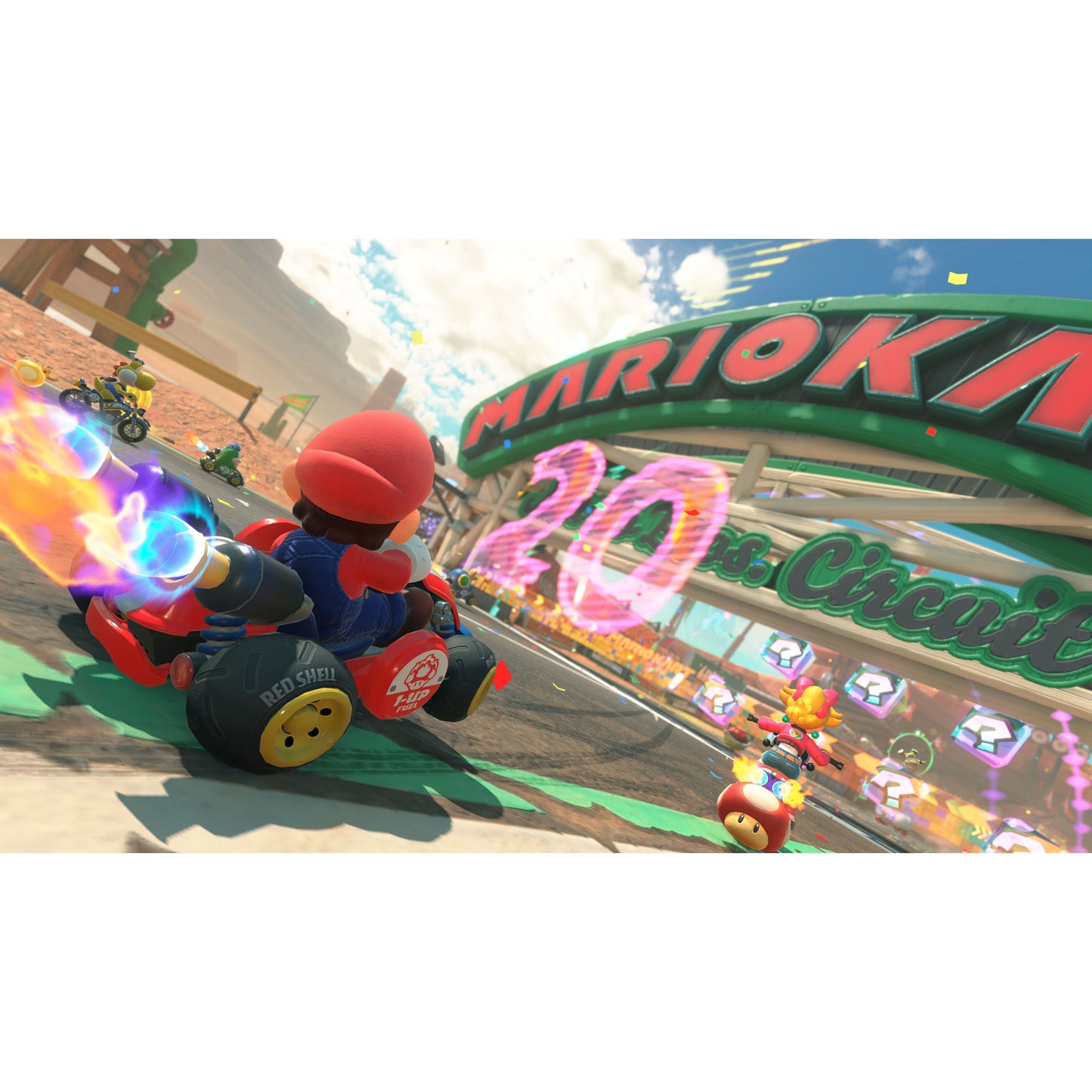 Mario i Nintendo Mario Kart Verden Switch 2 kører på bane under Mario Kart-banner og "20"-skilt sammen med andre figurer.
