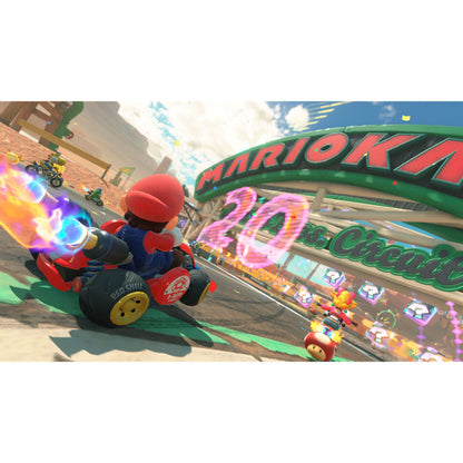 Mario i Nintendo Mario Kart Verden Switch 2 kører på bane under Mario Kart-banner og "20"-skilt sammen med andre figurer.