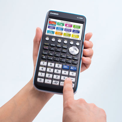 Casio FX-CG50 grafregner med farveskærm, synlige ikoner og 3D-graf funktion, holdes i hånden, knap trykkes.