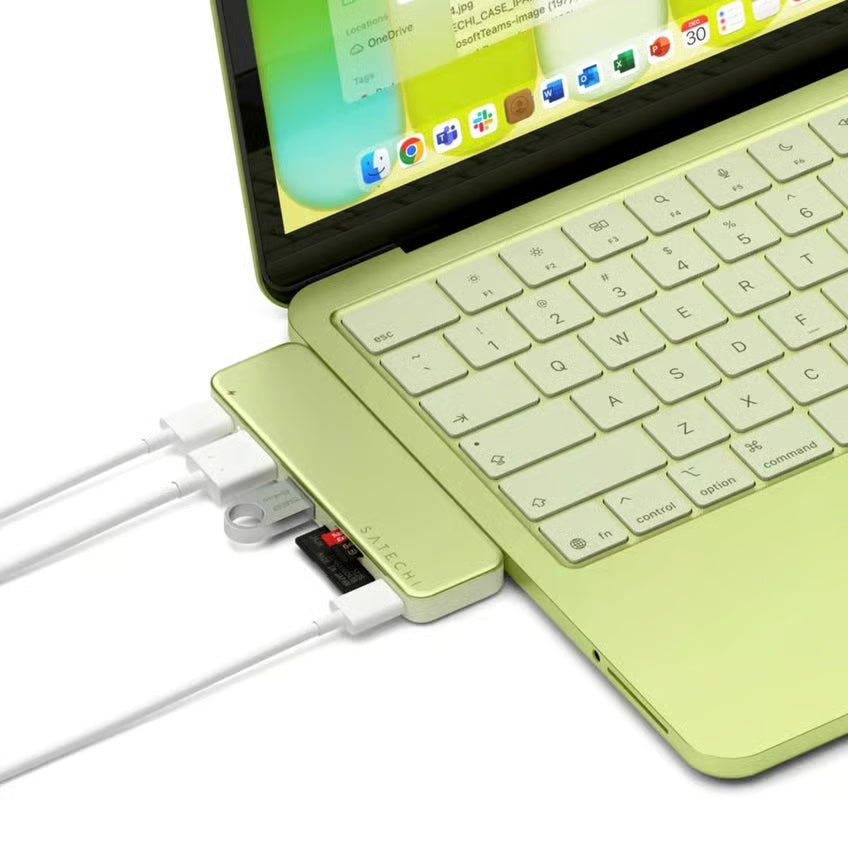MacBook Neo i lysegrøn med Satechi USB-C Snap Hub Neo i citrusfarve, flere kabler og SD-kort tilsluttet, seks porte synlige.