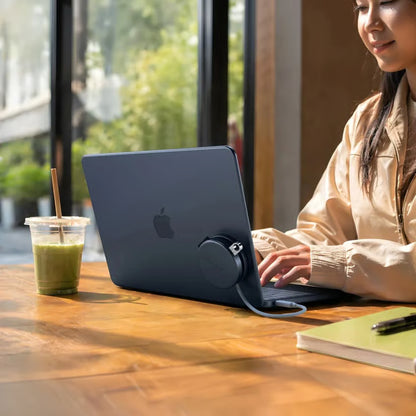 MacBook Neo med tilsluttet OnTheGo 5-i-1 Neo USB-C-hub i farven Indigo på bordet; hubben ses ved siden af den bærbare computer og en isdrink.