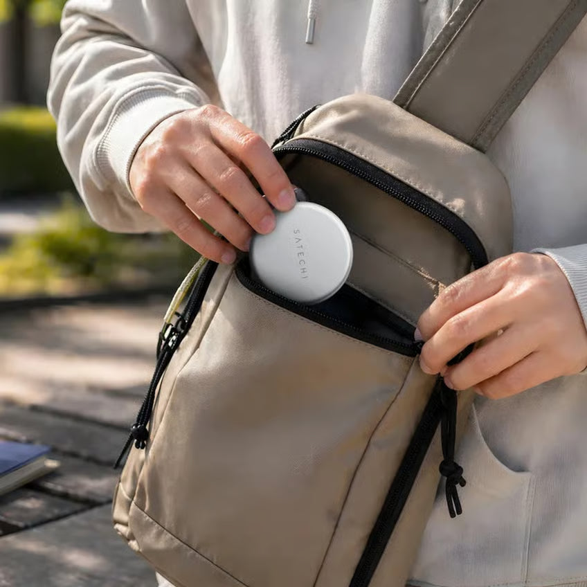 Satechi OnTheGo 5-i-1 Neo USB-C-hub, rund og sølvfarvet, ligger i forlommen på en beige skuldertaske.