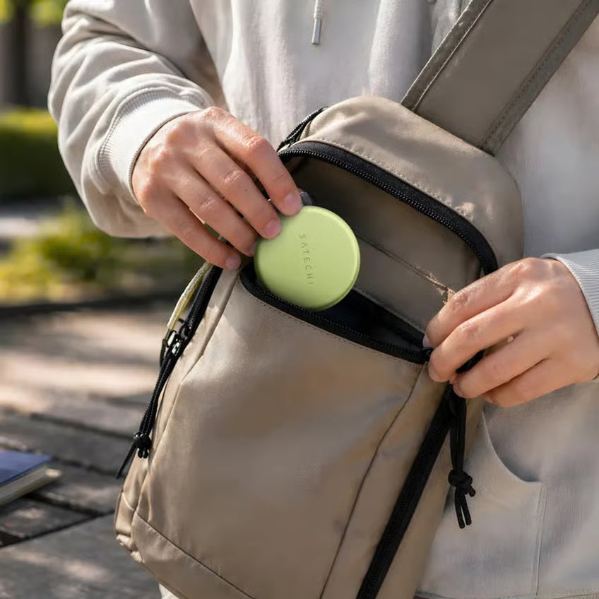 Satechi OnTheGo 5-i-1 Neo og USB-C-hub i citrusfarve med SATECHI-logo placeres i forlommen på en beige skuldertaske.