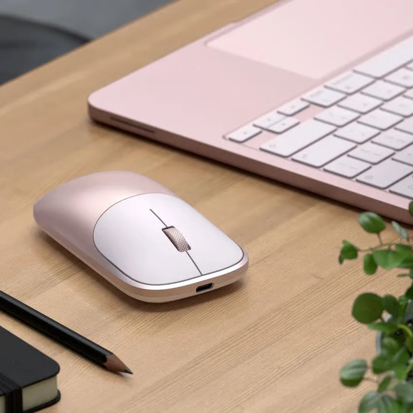 SATECHI Slim EX i farven Rouge med Bluetooth 5.3 ved siden af en matchende bærbar computer på et træbord, med en synlig notesbog og en blyant.