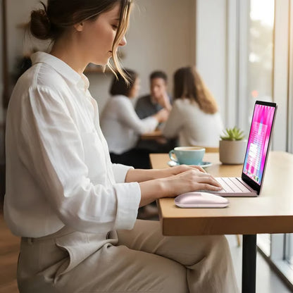 SATECHI Slim EX i farven »Rouge« bruges sammen med en bærbar computer på et cafébord, med en synlig kaffekop og en lille plante.