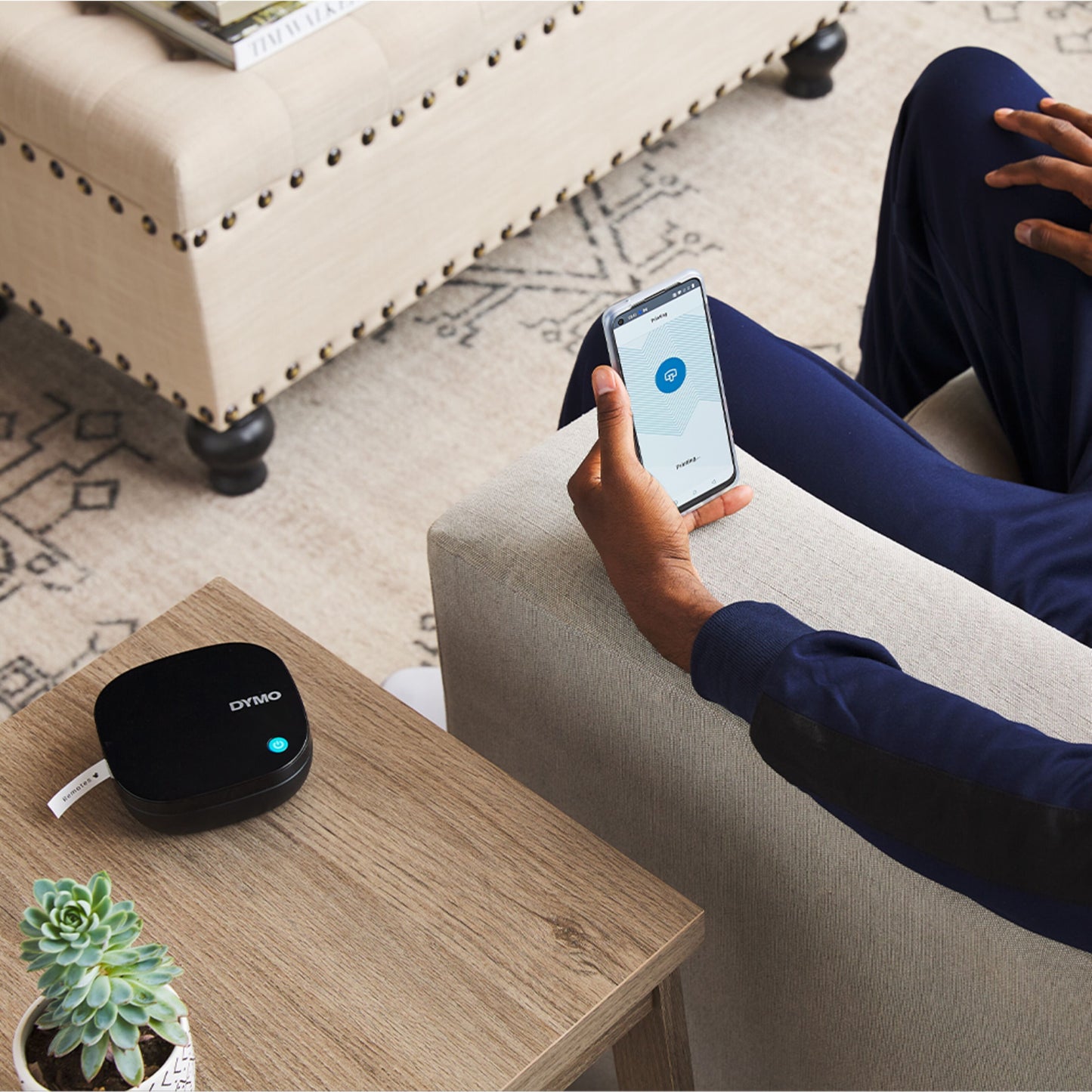 TP-Link enhed og Dymo Letratag 200B trådløs etiketprinter på træbord ved siden af smartphone med smart home app.