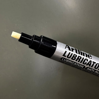 Artline Smøremiddelpen med skrå spidser, præcis smøring og anti-rust, nærbillede på grå baggrund.