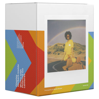 Polaroid Go Film Dobbelt Pakke 16 billeder, æske med grafisk mønster og Polaroid-foto af person i gult på bildak under regnbue.