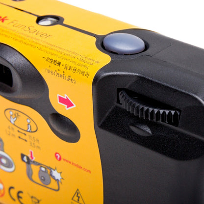 Kodak Engangskamera med blitz 27 billeder, gul/sort, sort udløserknap, fremføringshjul og illustrerede instruktioner.