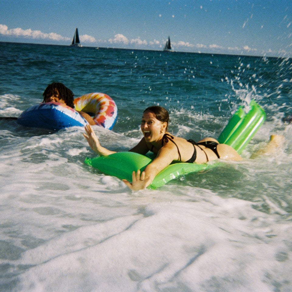 Fujifilm QuickSnap Flash Engangskamera 27 billeder i brug på strand med grøn oppustelig luftmadras, bikini sort.