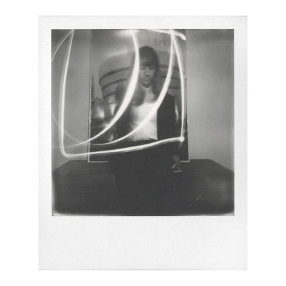 Polaroid i-Type sort/hvid film til Polaroid Now og Onestep 2 med motiv af kvinde indendørs, lysspor, moderne baggrund.
