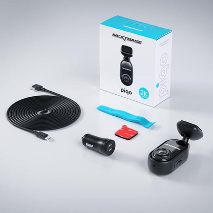 Nextbase Piqo 2K dashcam sæt med kamera, lang USB-kabel, biloplader, klæbemount, blåt værktøj og æske.