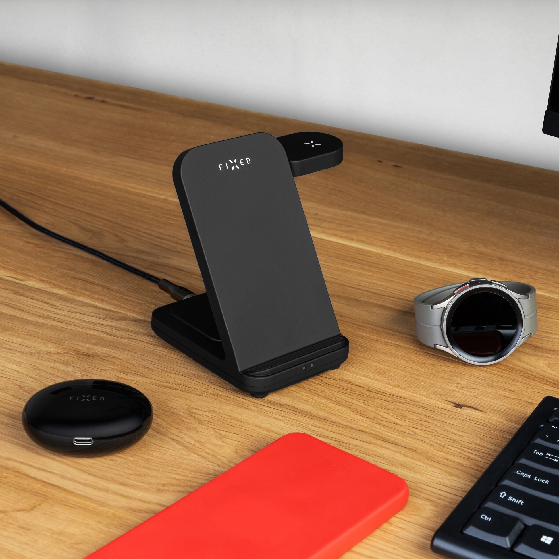 Fixed Powerstation 3-i-1 opladningsstation sorterer med trådløs opladning ved Samsung Watch, sorterer ørepropper og rød telefon.
