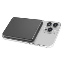Sort, rektangulær LINOCELL magnetisk powerbank på 5000 mAh med MagSafe 15 W/20 W og USB-C, monteret på en sølvfarvet smartphone med tre bagkameraer.