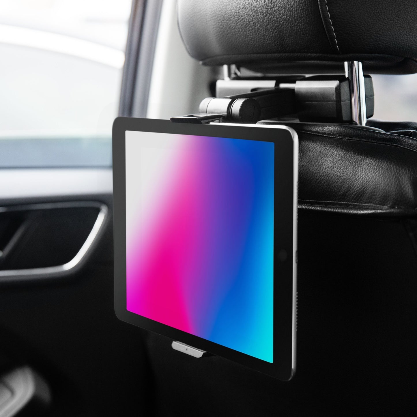Linocell tabletholder til bil med 360° rotation monteret på nakkestøtte, holder tablet med farvet skærm, bilinteriør synligt.