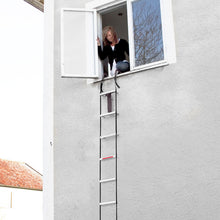 Housegard Brandledder 4,5 m rebstige fra vindue til jord langs grå mur, vises i brug under evakuering.