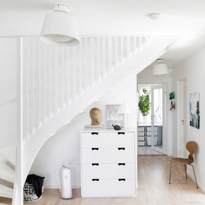 Housegard Brandslukker Design Edition pulver 6 kg hvid ved kommode, lyse trægulve og hvid trappe synlig.