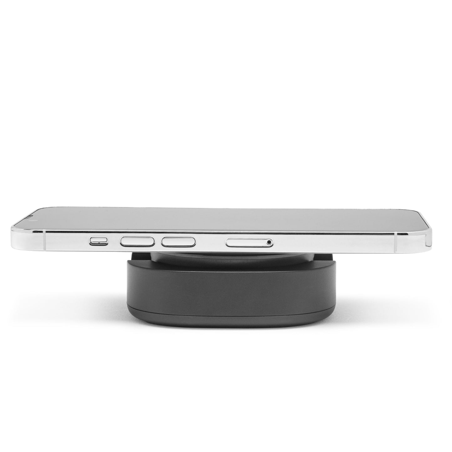 IPhone 12-16 ligger vandret på rund sort Magnetisk mobilholder til trådløs opladning set fra siden.