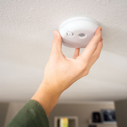 Housegard Pebble røgalarm monteres eller testes på hvidt loft.