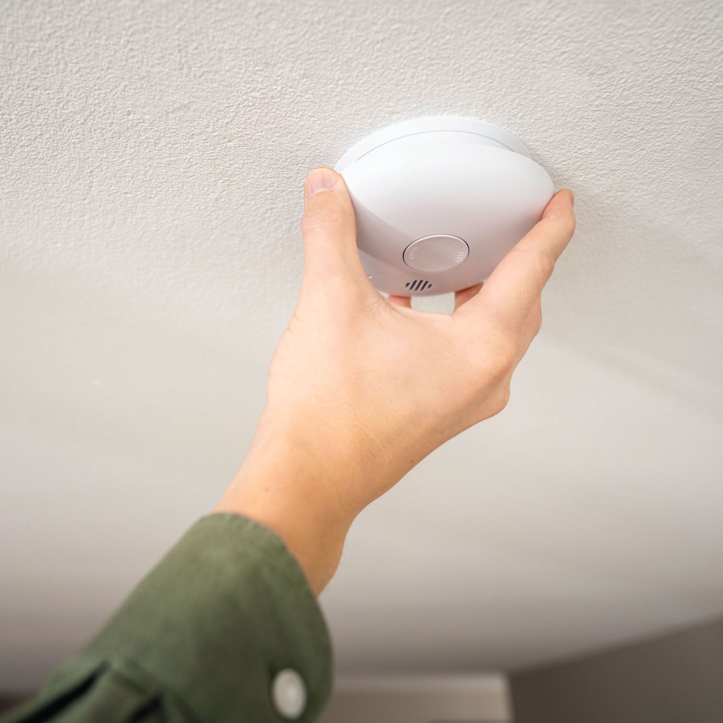 Housegard Pebble 10 optisk røgalarm monteres på hvidt loft, rund hvid model med optisk røgdetektion.