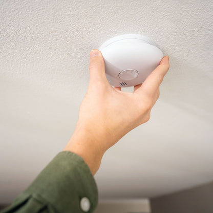 Housegard Pebble 10 optisk røgalarm monteres på hvidt loft, rund hvid model med optisk røgdetektion.