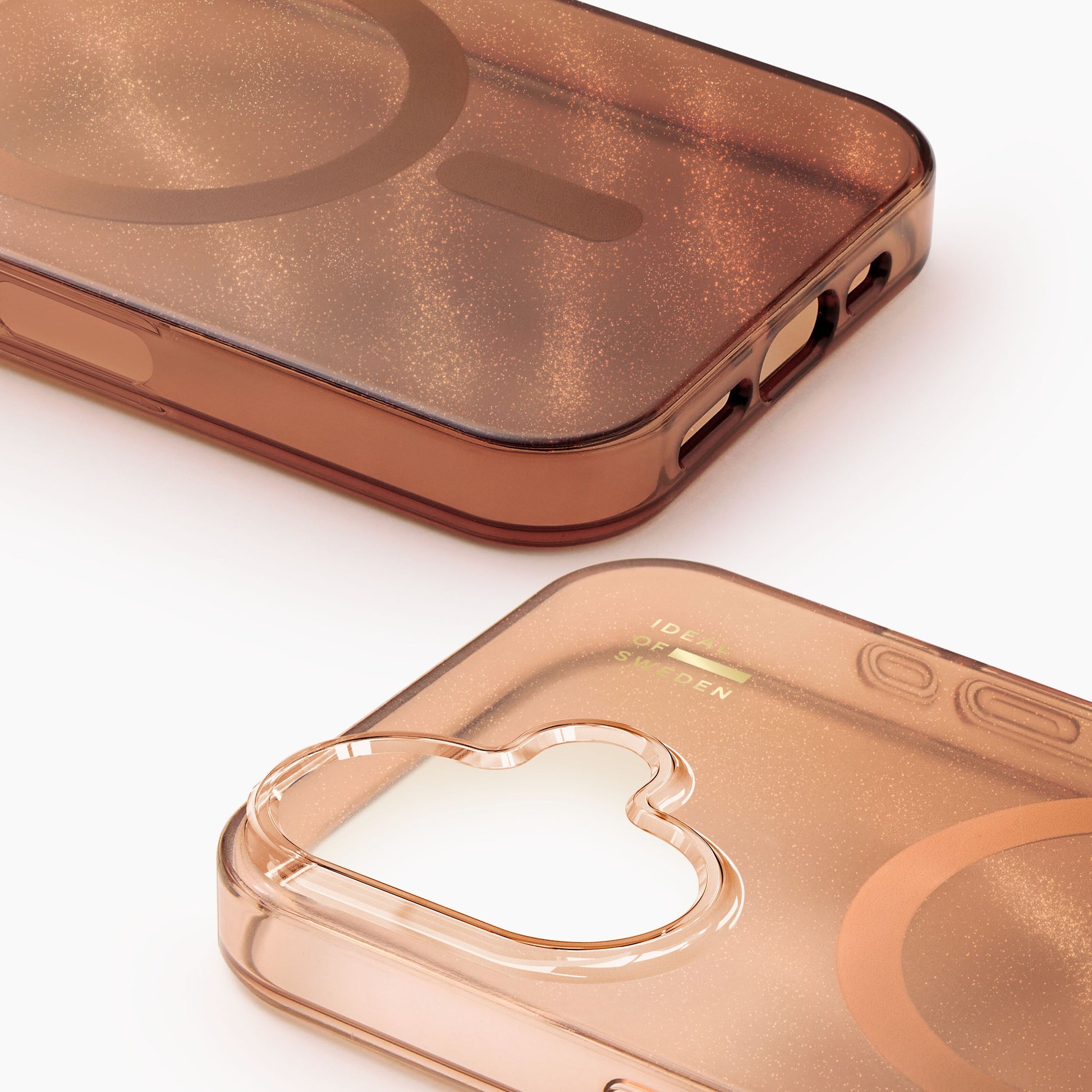 IDEAL OF SWEDEN Clear MagSafe Case iPhone 16 Mocha Mousse, brun, rund MagSafe-ring og hjerteformet kamerahul.