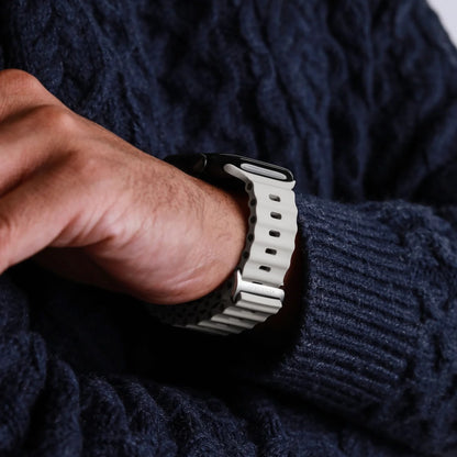Vonmählen Wave Band 2 til Apple Watch, creme, ses på håndled, person i mørkeblå sweater med armene over kors.