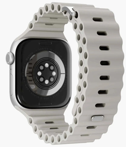 Apple Watch sølv bagside med Vonmählen Wave Band 2 silikonerem, creme, synlige sensorer og præget remstruktur.