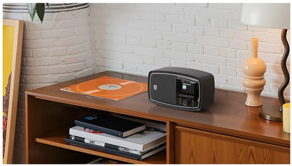 Philips The Janet bærbar retroradio DAB+ Bluetooth sort vises med vinylplade i cover, keramiklampe og bøger.