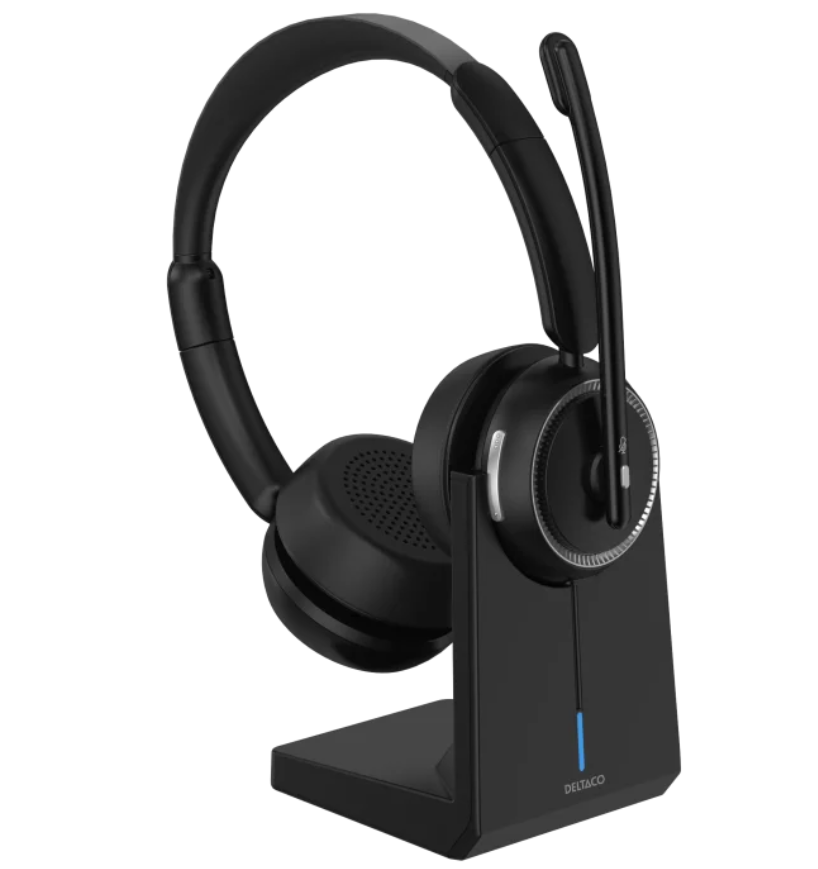 Deltaco trådløst stereo headset sort med Bluetooth 5.2, indbygget mikrofon, på ladestander med blå indikatorlys.