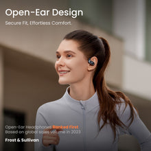 Shokz OpenFit Air trådløse øretelefoner sort, open-ear design, bæres af kvinde i sportstøj under løbetur.