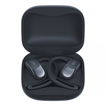 Shokz OpenFit Air trådløse øretelefoner sorterer i åben opladeetui med synlige ørekroge og begge enheder på plads.