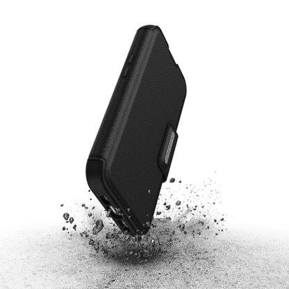 Otterbox Strada MagSafe cover til iPhone 15 Pro sort, vises i robust design med støv, fremhæver stødmodstand.