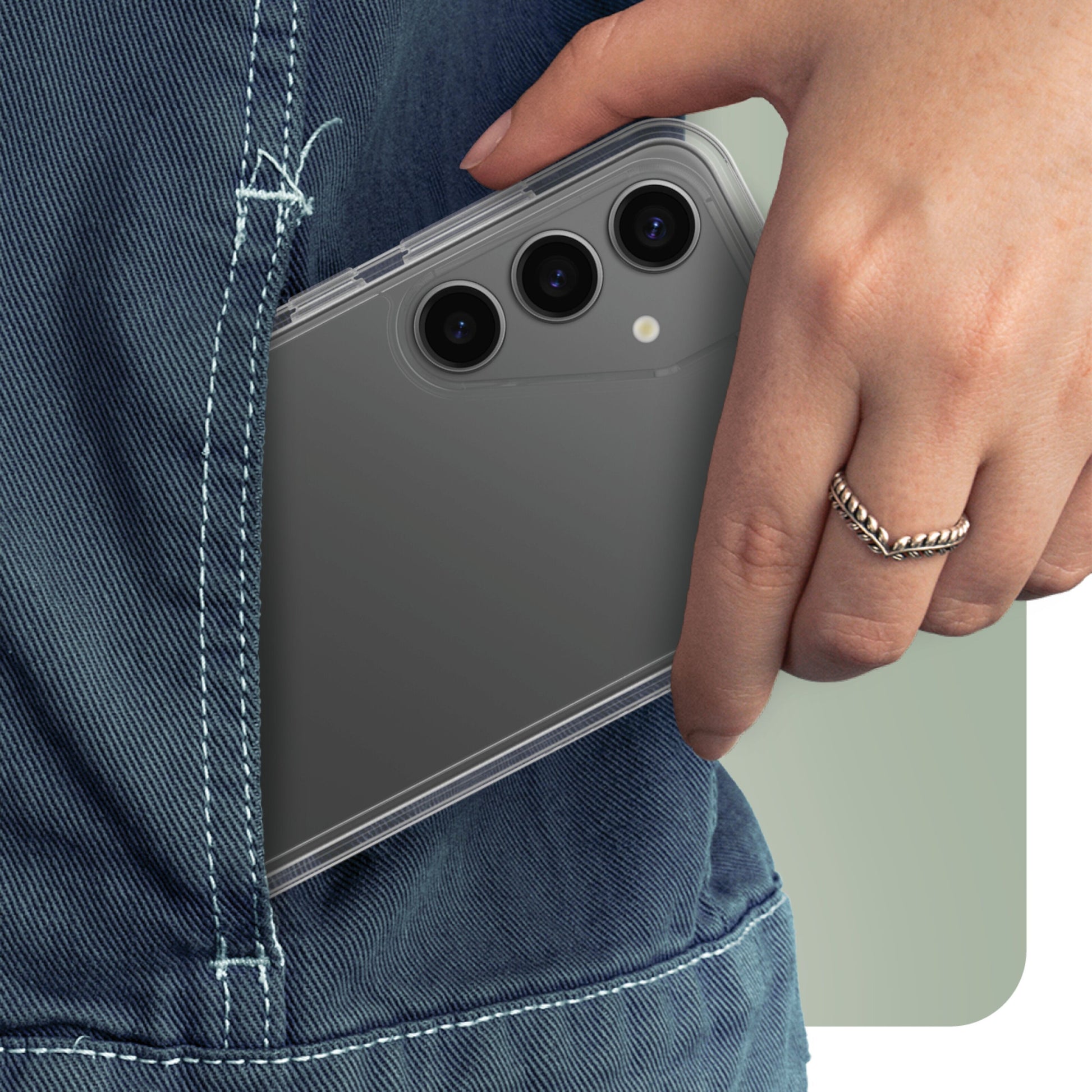 Samsung Galaxy S24 Plus grå med tre bagkameraer og gennemsigtigt cover placeres i baglommen på blå jeans.
