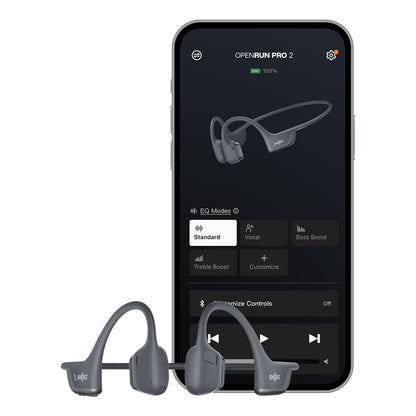 Shokz OpenRun Pro 2 trådløse hovedtelefoner vist foran en smartphone med Shokz høretelefonkontrol på skærmen.