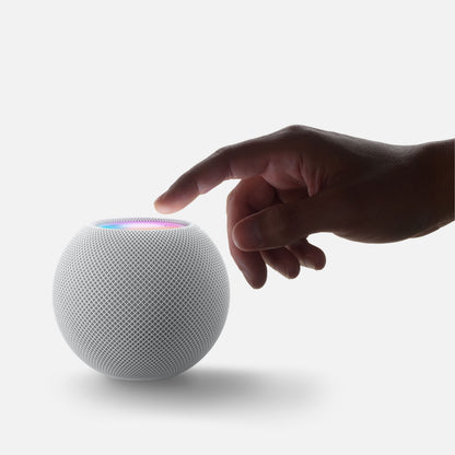Apple HomePod mini Midnat smart højtaler med mesh-design og lysende touchflade, vises med en hånd der nærmer sig.