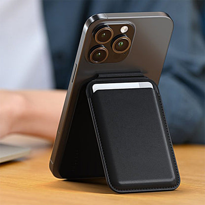 Smartphone med tre bagkameraer står i Satechi Magnetisk Kortholder med støttefunktion, laptop sløret i baggrunden.