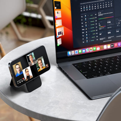 Satechi magnetisk kortholder med støttefunktion i vegansk læder til iPhone 12, vist med videoopkald ved siden af laptop.